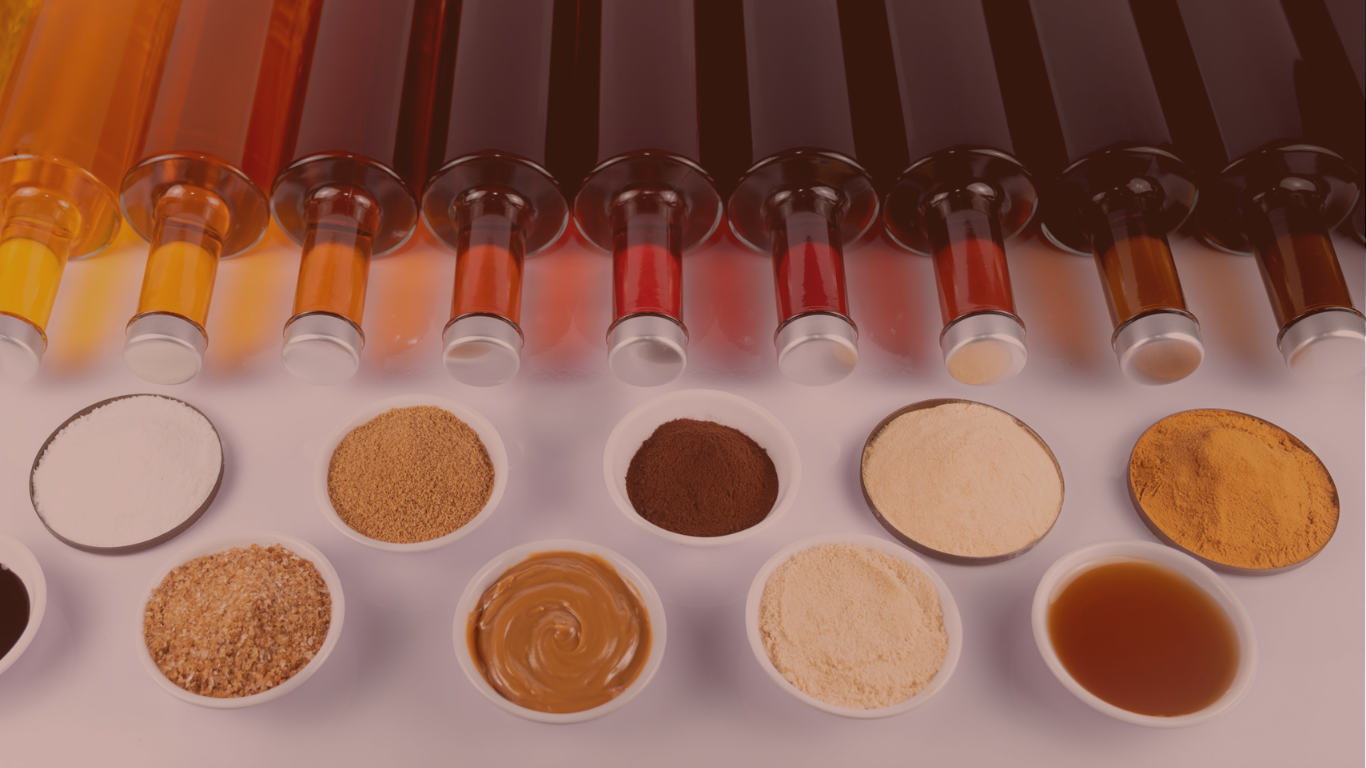 Reihung bunter Glasflaschen mit Flüssigkeiten über Schälchen verschiedener Pulver und Pasten.