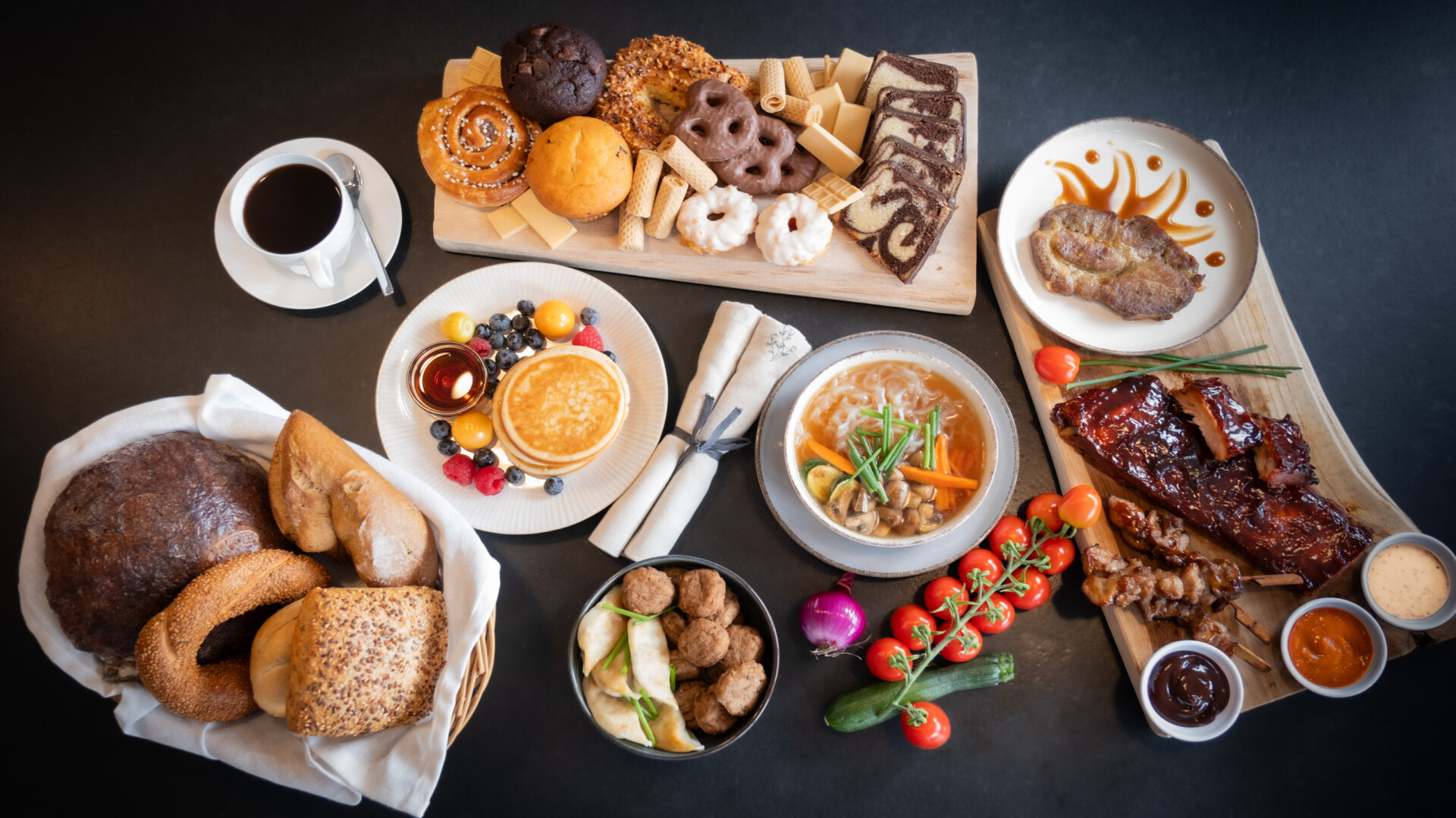 Vielfältiges Buffet mit Brot, Gebäck, Pfannkuchen, Suppe, Fleisch, Soßen und Gemüse.